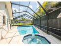 Enclosed pool area with pristine pool and spa provides a tranquil escape from the Florida heat at 1830 Oak Forest S Dr, Clearwater, FL 33759