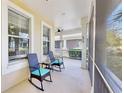 Inviting screened porch furnished with rocking chairs offering a cozy spot to enjoy the peaceful neighborhood scenery at 203 Oceania Ct, Apollo Beach, FL 33572