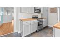 Kitchen featuring tile floors, butcher block countertops, stainless steel appliances, and updated gray cabinets at 322 11Th N Ave, St Petersburg, FL 33701
