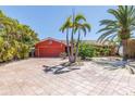 Charming home featuring a spacious driveway and tropical landscaping with palm trees at 351 S Julia Cir, St Pete Beach, FL 33706