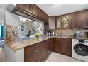 Modern kitchen featuring brown cabinetry, granite countertops, and stainless steel appliances at 6800 20Th N Ave # 309, St Petersburg, FL 33710