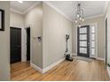Open foyer with wood flooring, a black front door, and a convenient vacuum storage area at 9310 N Willow Ave, Tampa, FL 33612