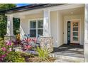 Inviting front porch with rocking chairs, stone pillars, and a pink front door at 9310 N Willow Ave, Tampa, FL 33612