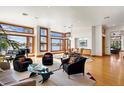Bright and spacious living area with hardwood floors, a piano, and multiple windows offering picturesque views of the water at 950 Monterey Ne Pt, St Petersburg, FL 33704