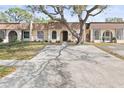 Attractive home showcasing a large driveway, mature trees, and a well-kept lawn at 9845 84Th Way, Seminole, FL 33777