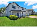 Charming two-story home with a three car garage, manicured lawn and a welcoming front porch at 11486 June Briar Loop, San Antonio, FL 33576