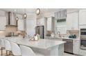 Modern kitchen with stainless steel appliances, a large island, and stylish pendant lighting at 3559 Santa Caterina Blvd, Bradenton, FL 34211