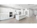Bright kitchen featuring stainless steel appliances, a central island, and white cabinets at 3563 Santa Caterina Blvd, Bradenton, FL 34211