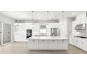 Modern kitchen with large island, stainless steel appliances, and white cabinetry at 3563 Santa Caterina Blvd, Bradenton, FL 34211