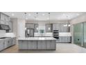 Modern kitchen featuring gray cabinets, a large island, stainless steel appliances, and sliding glass doors at 3575 Santa Caterina Blvd, Bradenton, FL 34211