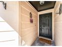Covered front porch with welcome sign and dark front door with hardware at 712 Hazy Meadow Ct, Brandon, FL 33510