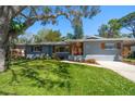 Charming single-story home featuring a lush front lawn, colorful landscaping, and inviting curb appeal at 1220 Parkview Ln, Largo, FL 33770