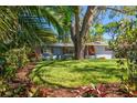 Charming single-story home framed by lush tropical landscaping and a beautiful shade tree at 1220 Parkview Ln, Largo, FL 33770