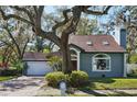 Charming home featuring a brick driveway, attached garage, and mature landscaping at 14910 Northwood Village Ln, Tampa, FL 33613