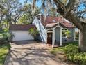 Charming home featuring a brick driveway, attached garage, and a welcoming front entrance with stately columns at 14910 Northwood Village Ln, Tampa, FL 33613