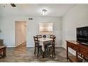 Dining area with wood-look flooring and a view of the bright kitchen through a pass-through window at 2042 Australia W Way # 6, Clearwater, FL 33763