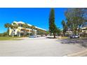 Attractive exterior view of a multi-story building featuring palm trees and parking spaces at 2222 Norwegian Dr # 24, Clearwater, FL 33763