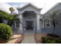 Inviting front entrance with palm trees, decorative columns, and well-maintained landscaping at 2233 Golf Manor Blvd, Valrico, FL 33596