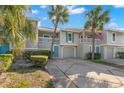Charming townhouse featuring a two-story facade, lush landscaping, and an inviting private entrance with garage at 238 Sun Ketch Ct # 95, Treasure Island, FL 33706