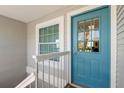 Stylish turquoise front door with glass panels and white trim, complemented by a matching window and white railings at 238 Sun Ketch Ct # 95, Treasure Island, FL 33706