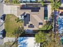 Aerial view of property featuring a pool, solar panels, and paved driveway at 2451 Baywood W Dr, Dunedin, FL 34698