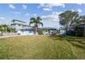 Charming single-story home with a well-manicured lawn and beautiful palm trees at 2451 Baywood W Dr, Dunedin, FL 34698