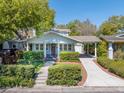 Quaint bungalow featuring a covered porch, carport, and lush green landscaping at 3007 W Angeles St, Tampa, FL 33629