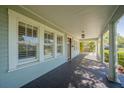 Inviting covered porch with dark wood flooring and white pillars, a perfect spot for relaxing at 3007 W Angeles St, Tampa, FL 33629