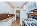 Well-lit kitchen featuring white cabinets, laminate floors, stainless steel appliances, and granite countertops at 3010 59Th S St # 314, Gulfport, FL 33707
