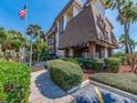 Elegant exterior view of the community with an American flag and mature landscaping at 3021 Countryside Blvd # 23A, Clearwater, FL 33761