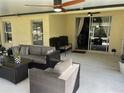 A well-decorated outdoor living space with comfortable seating and sliding glass doors at 3207 Sunwatch Dr, Wesley Chapel, FL 33544