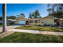 Charming single-story home with manicured lawn, decorative fountain, and a paved driveway leading to the garage at 3531 Glossy Ibis Ct, Palm Harbor, FL 34683