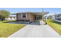 Cozy home featuring covered parking, a well maintained lawn and mature trees at 37246 Eileen Ave, Zephyrhills, FL 33542