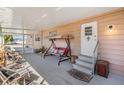 Relaxing covered patio featuring a swing, chairs, and screened in area at 37246 Eileen Ave, Zephyrhills, FL 33542