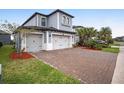 Beautiful two-story home boasts a paver driveway and a three-car garage at 4575 Tivoli Dr, Wesley Chapel, FL 33543