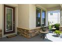 Inviting front porch with decorative stone accents and stylish front door at 5006 Ivory Stone Dr, Wimauma, FL 33598
