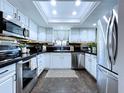 Well-lit kitchen showcases white cabinets, stainless steel appliances, and a decorative backsplash at 513 Hammock Pine Blvd, Clearwater, FL 33761
