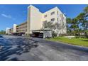 Condominium building featuring a covered parking area and well-maintained landscaping at 5920 80Th N St # 107, St Petersburg, FL 33709