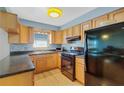 Efficient kitchen with wooden cabinets, black appliances, and natural light at 8457 Deauville # 8457, Pinellas Park, FL 33781