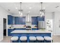 Stunning kitchen features blue cabinets, stainless steel appliances and pendant lighting at 901 Eagle Ln, Apollo Beach, FL 33572