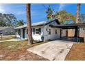 A single-story home showing driveway with covered parking along the side of the house at 921 7Th Nw St, Largo, FL 33770