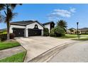 Wide driveway leading to a lovely two-story home featuring black trim and lush landscaping at 6927 Crestpoint Dr, Apollo Beach, FL 33572