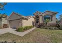Inviting single-story home with beautiful landscaping and a well-maintained lawn at 1010 Blue Heron Way, Tarpon Springs, FL 34689