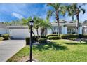 Charming home featuring a well-manicured lawn, mature palm trees and a welcoming lamp post at 1034 Mcdaniel St # 1034, Sun City Center, FL 33573