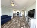 Open-concept living space featuring modern flooring, ceiling fan, and a comfortable blue sofa at 105 W Saint Johns Way, Apollo Beach, FL 33572
