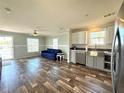 Stylish living area with a modern ceiling fan, gray backsplash, and a comfortable blue sofa at 105 W Saint Johns Way, Apollo Beach, FL 33572
