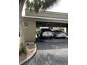 View of the carport showing the parking space with 2 vehicles parked beneath a wooden covering at 111 Woodland Pl, Osprey, FL 34229