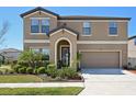 Charming two-story home featuring an arched entryway, a well-manicured lawn, and an attached two-car garage at 14637 Red Castle Ave, Lithia, FL 33547