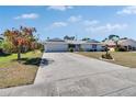 Well maintained single story home with a long driveway and a beautiful blooming tree in the front yard at 1508 W Del Webb Blvd, Sun City Center, FL 33573