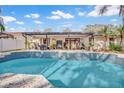 Relaxing outdoor space features a sparkling pool, covered patio and lush tropical landscaping at 230 Lotus Dr, Safety Harbor, FL 34695